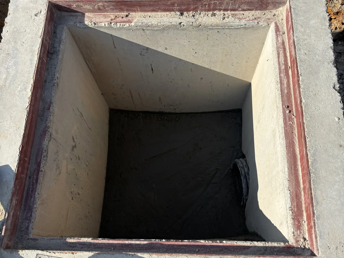 Interior view looking into a large open concrete box structure below grade